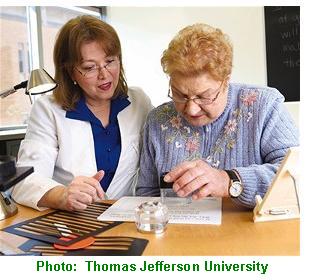 An occupational therapist at Thomas Jefferson University works with a patient who has low vision.